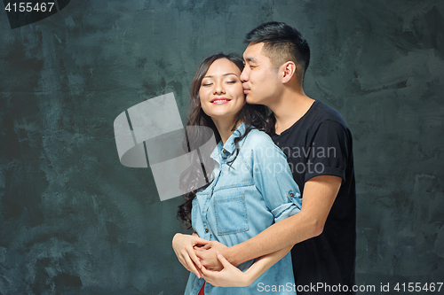 Image of Portrait of smiling Korean couple on a gray