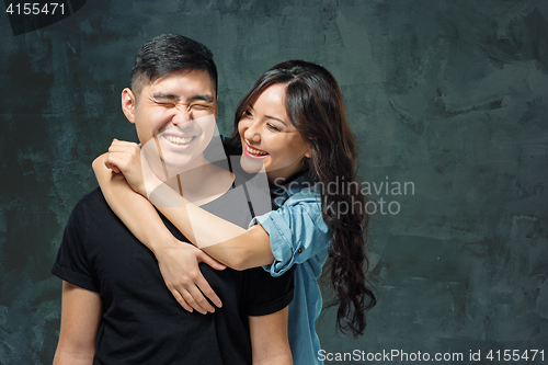 Image of Portrait of smiling Korean couple on a gray