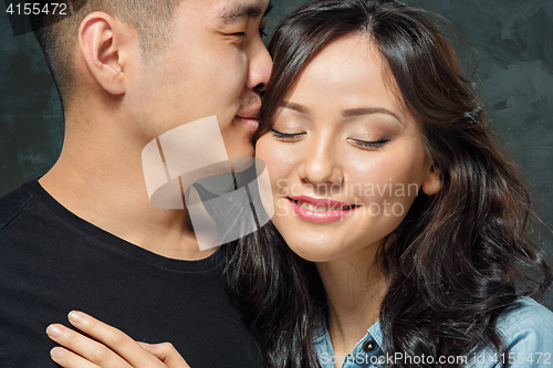 Image of Portrait of smiling Korean couple on a gray