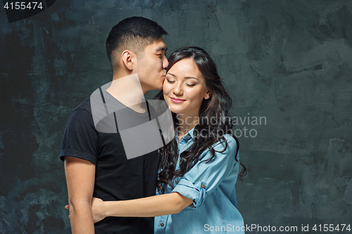 Image of Portrait of smiling Korean couple on a gray