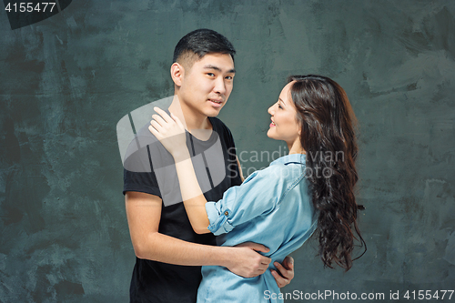Image of Portrait of smiling Korean couple on a gray