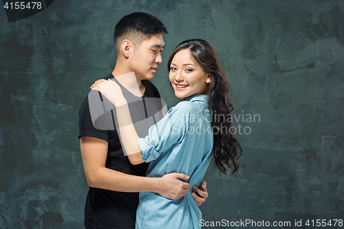 Image of Portrait of smiling Korean couple on a gray