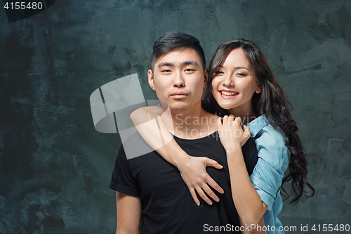Image of Portrait of smiling Korean couple on a gray