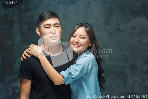 Image of Portrait of smiling Korean couple on a gray