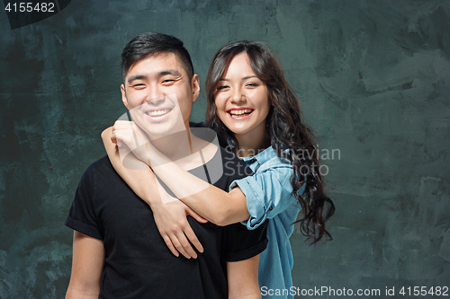 Image of Portrait of smiling Korean couple on a gray