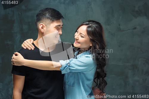 Image of Portrait of smiling Korean couple on a gray