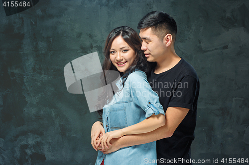 Image of Portrait of smiling Korean couple on a gray