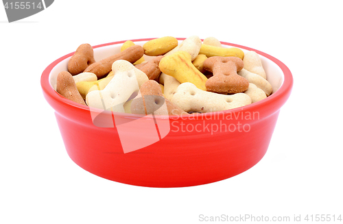 Image of Dry bone-shaped dog biscuits in a red pet food bowl
