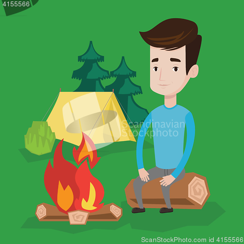 Image of Man sitting on log near campfire in the camping.