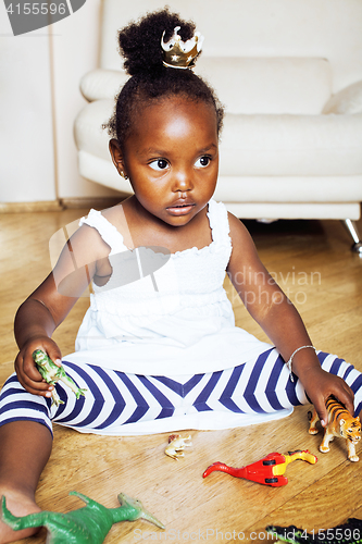 Image of little cute african american girl playing with animal toys at ho