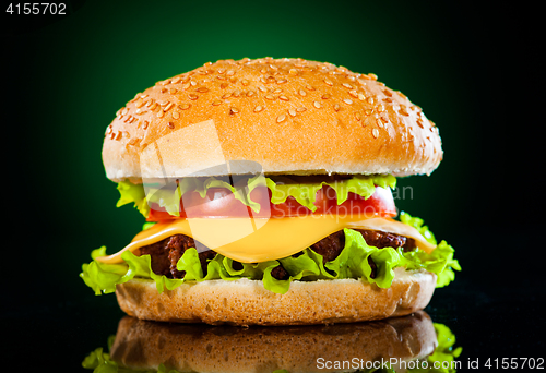 Image of Tasty and appetizing hamburger on a darkly green