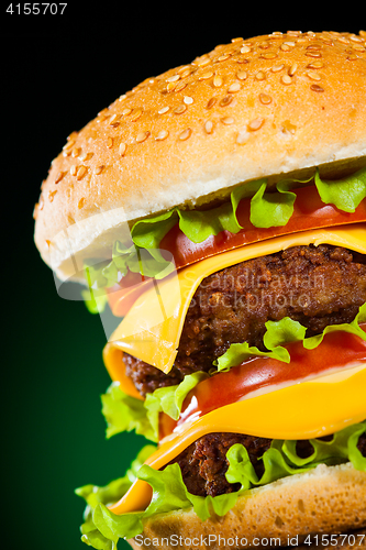 Image of Tasty and appetizing hamburger on a darkly green