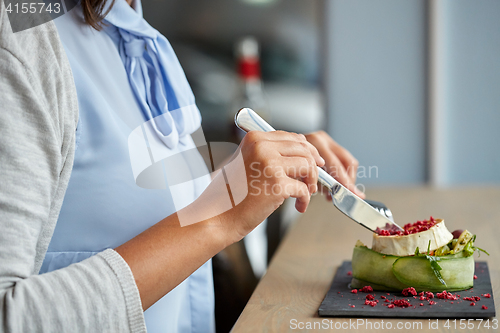 Image of woman eating goat cheese salad at restaurant