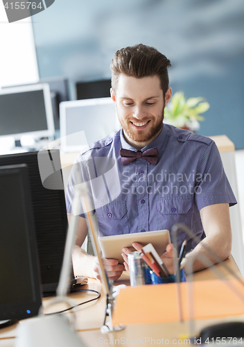 Image of happy creative male office worker with tablet pc