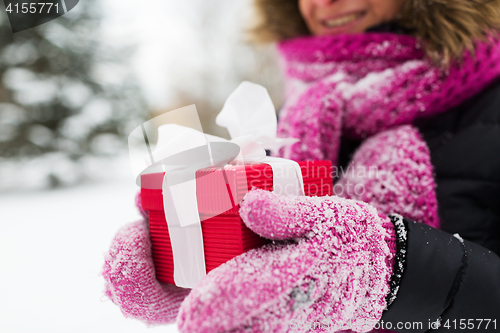 Image of close up of woman with christmas gift outdoors