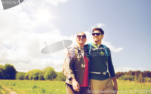 Image of happy couple with backpacks hiking outdoors