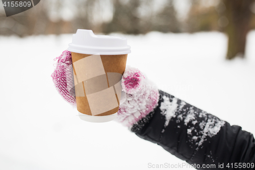 Image of close up of hand with coffee outdoors in winter