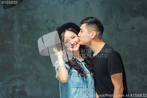 Image of Portrait of smiling Korean couple on a gray