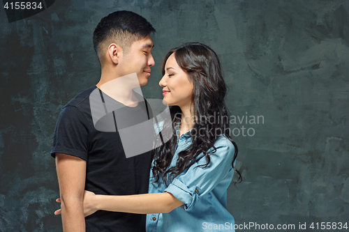 Image of Portrait of smiling Korean couple on a gray