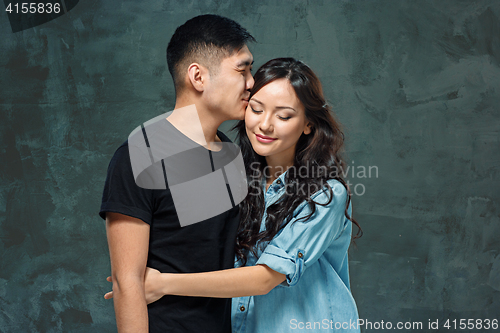 Image of Portrait of smiling Korean couple on a gray