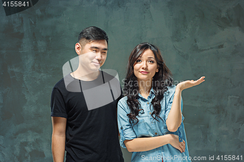Image of Portrait of smiling Korean couple on a gray