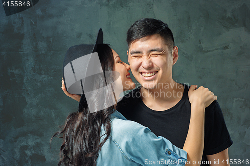 Image of Portrait of smiling Korean couple on a gray