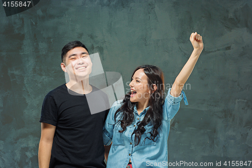 Image of Portrait of smiling Korean couple on a gray