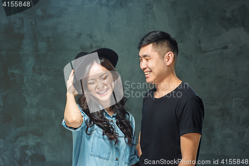 Image of Portrait of smiling Korean couple on a gray
