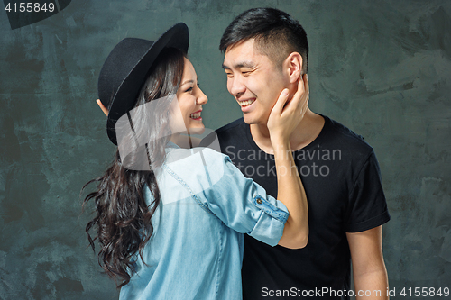 Image of Portrait of smiling Korean couple on a gray