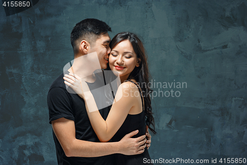 Image of Portrait of smiling Korean couple on a gray