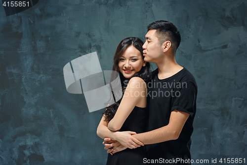 Image of Portrait of smiling Korean couple on a gray