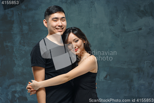 Image of Portrait of smiling Korean couple on a gray