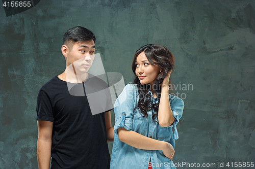 Image of Portrait of smiling Korean couple on a gray