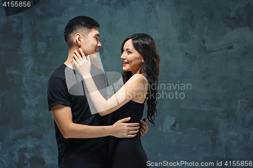 Image of Portrait of smiling Korean couple on a gray