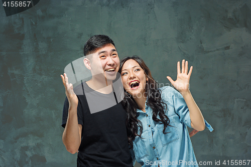 Image of Portrait of smiling Korean couple on a gray