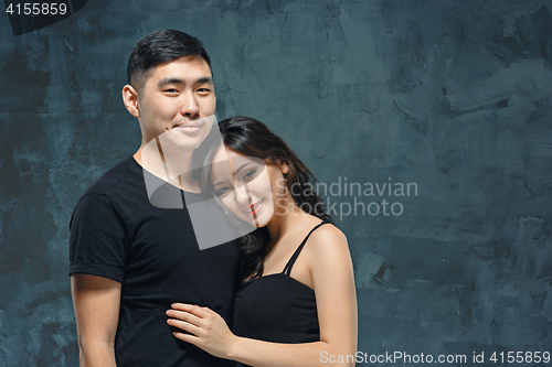 Image of Portrait of smiling Korean couple on a gray