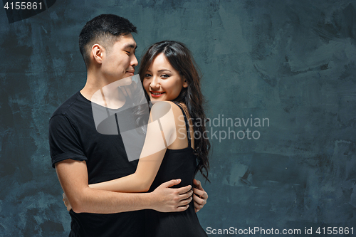 Image of Portrait of smiling Korean couple on a gray