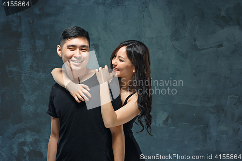 Image of Portrait of smiling Korean couple on a gray