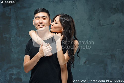 Image of Portrait of smiling Korean couple on a gray