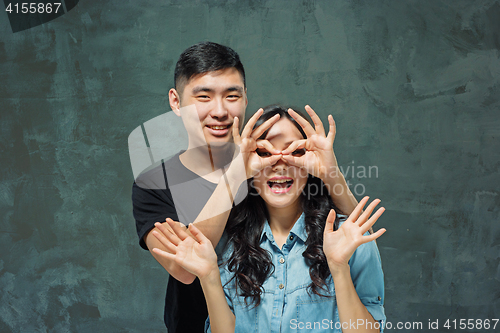 Image of Portrait of smiling Korean couple on a gray