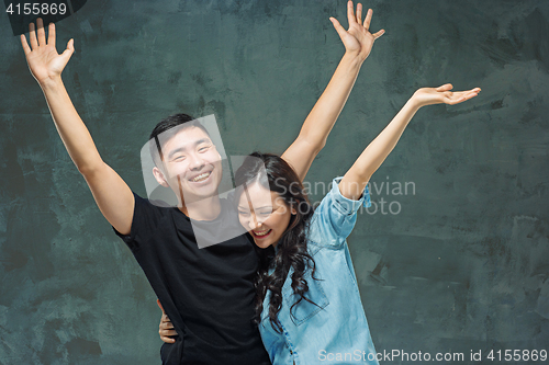 Image of Portrait of smiling Korean couple on a gray