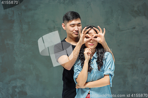 Image of Portrait of smiling Korean couple on a gray