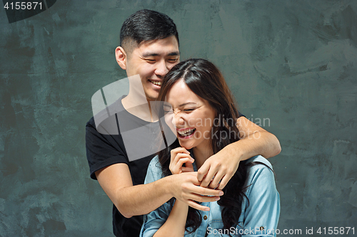 Image of Portrait of smiling Korean couple on a gray