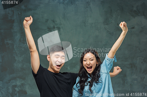 Image of Portrait of smiling Korean couple on a gray
