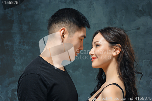 Image of Portrait of smiling Korean couple on a gray