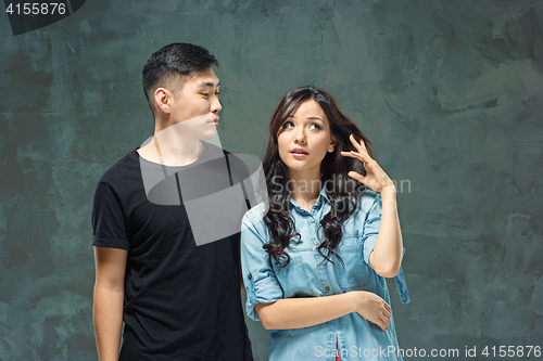 Image of Portrait of smiling Korean couple on a gray