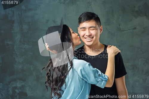 Image of Portrait of smiling Korean couple on a gray