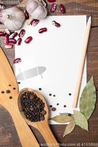 Image of paper for recipes and spices on wooden table