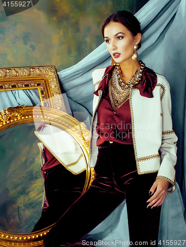 Image of beauty rich brunette woman in luxury interior near empty frames