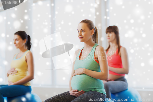 Image of happy pregnant women with exercise ball in gym